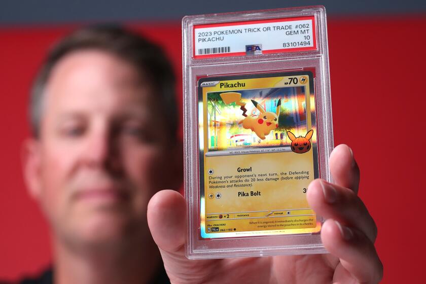 Ryan Hoge holds the very collectable grade 10, Pikachu trading card, part of the Pokemon card game series, at the new Professional Sports Authenticator (PSA) facility in Santa Ana.