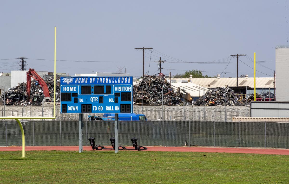 An employee moves debris at Atlas Iron & Metal Co., which is a metal recycler that has piles 