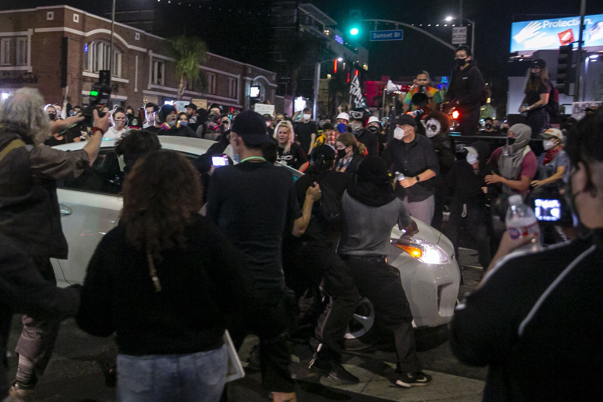 A Prius runs through a crowd of people on Sunset Boulevard during a protest held for Breonna Taylor in Hollywood
