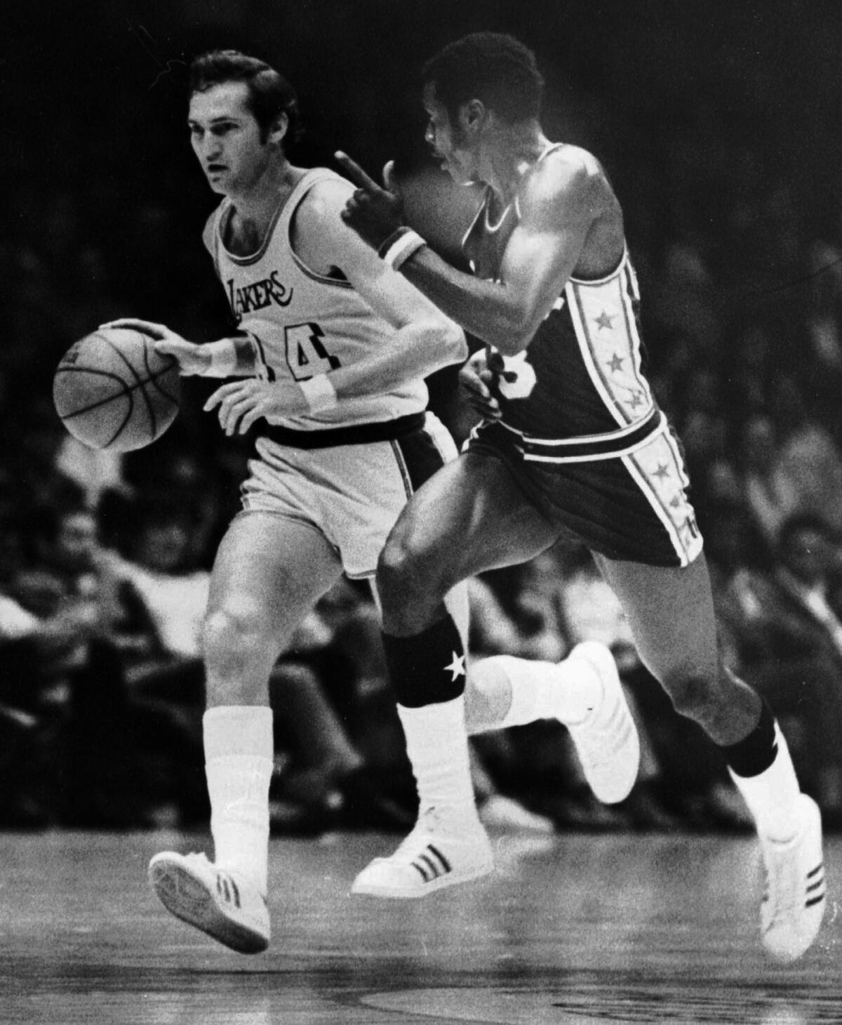 Lakers guard Jerry West is defended by 76ers guard Fred Carter while bringing the ball up court on Dec.19, 1971.