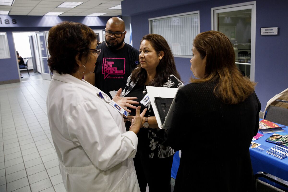 In an examination area set up at the Mexican Consulate, Planned Parenthood nurse practitioner Teresa Arellano, left, speaks with outreach director Fortina Hernandez and Lorena Ojeda, who gives presentations at the consulate.
