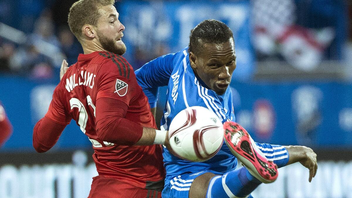 Impact forward Didier Drogba, right, tries to control the ball against Toronto FC's Josh Williams in the first half Thursday night.