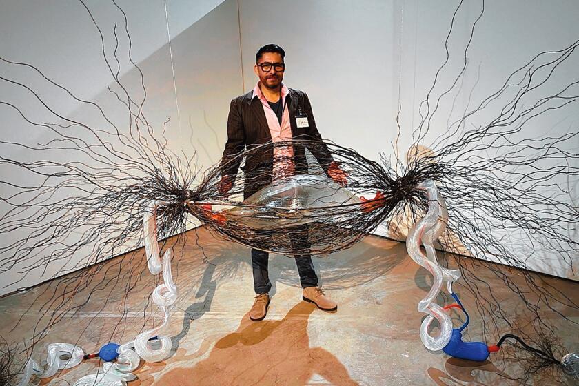 Glass artist Hugo Heredia Barrera, with his supersized cancer-infected cell, trapped in steel threads and connected by plastic DNA tubes to some still-healthy, clear-glass cells. 'Illumination: 21st century interactions with art, science and technology' is on exhibit through May 3, 2020 at San Diego Art Institute, 1439 El Prado in Balboa Park, San Diego. Hours: noon to 5 p.m. Tuesday-Sunday. (619) 236-0011. sandiego-art.org