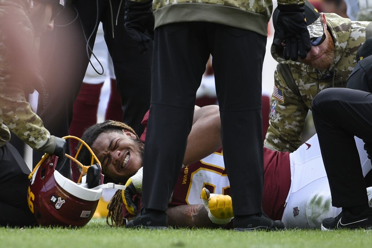 Washington Football Team defensive end Chase Young (99) is attended to after an injury during the first half of an NFL football game against the Tampa Bay Buccaneers, Sunday, Nov. 14, 2021, in Landover, Md.(AP Photo/Mark Tenally)