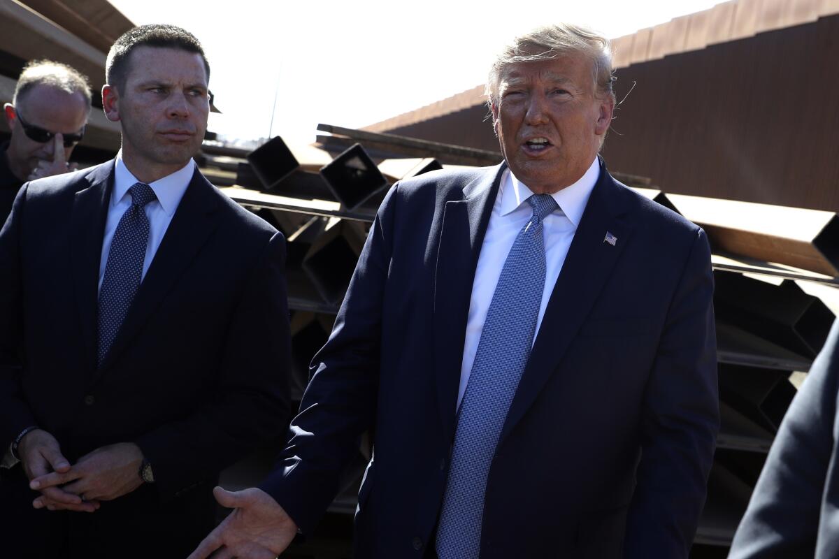 El presidente Trump habla con los periodistas mientras recorre una sección del muro de la frontera sur con el secretario interino de Seguridad Nacional, Kevin McAleenan, a la izquierda, en Otay Mesa, California, el miércoles.