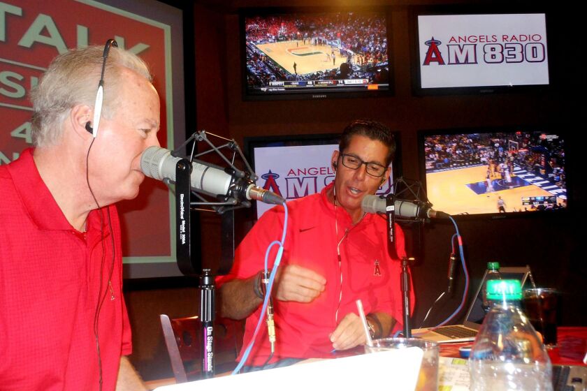 Broadcasters Terry Smith, left, and Victor Rojas talk to fans during a call-in show on 830 AM.
