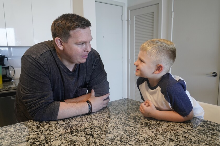 Associated Press investigative reporter James LaPorta and his son Joel, 5, sit at their home, Tuesday, Sept. 7, 2021, in Boca Raton, Fla. LaPorta recalls a boy he encountered in Afghanistan back in 2013 while serving as a Marine. (AP Photo/Marta Lavandier)