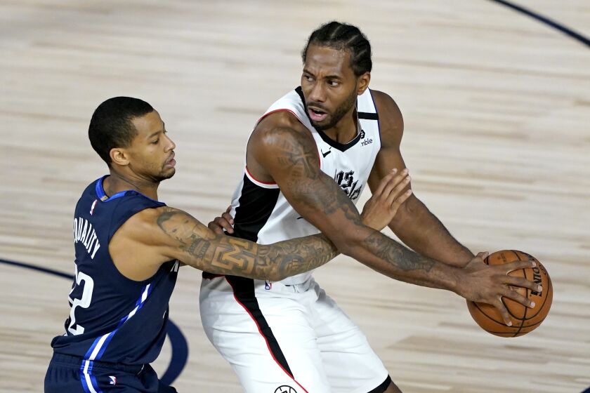 Los Angeles Clippers' Kawhi Leonard, right, is guarded by Dallas Mavericks' Trey Burke.