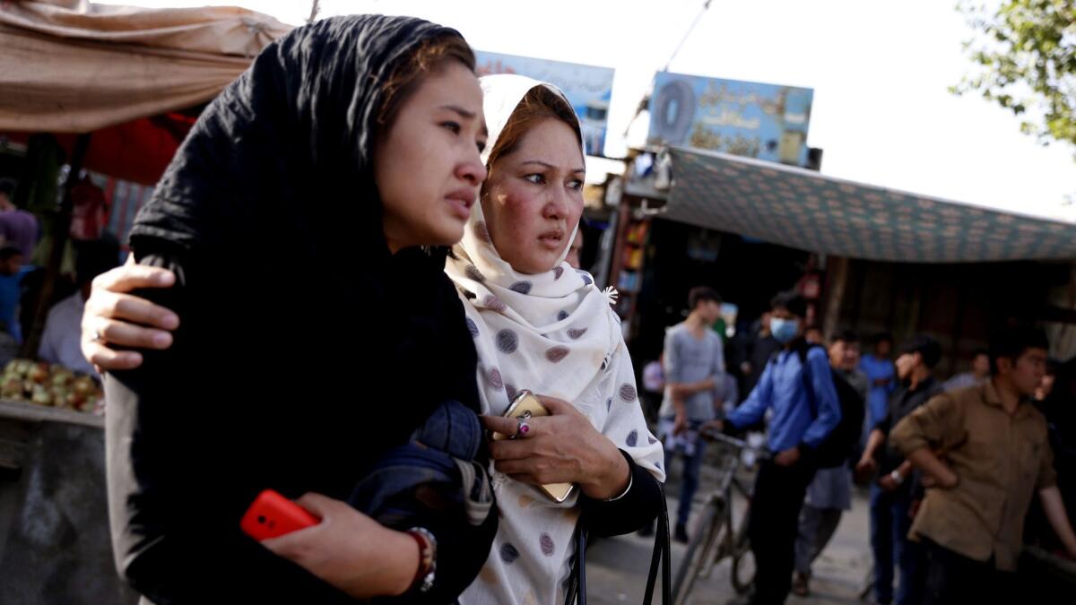 Women comfort each other at the scene of a suicide bomb attack in Kabul, Afghanistan, on Wednesday.