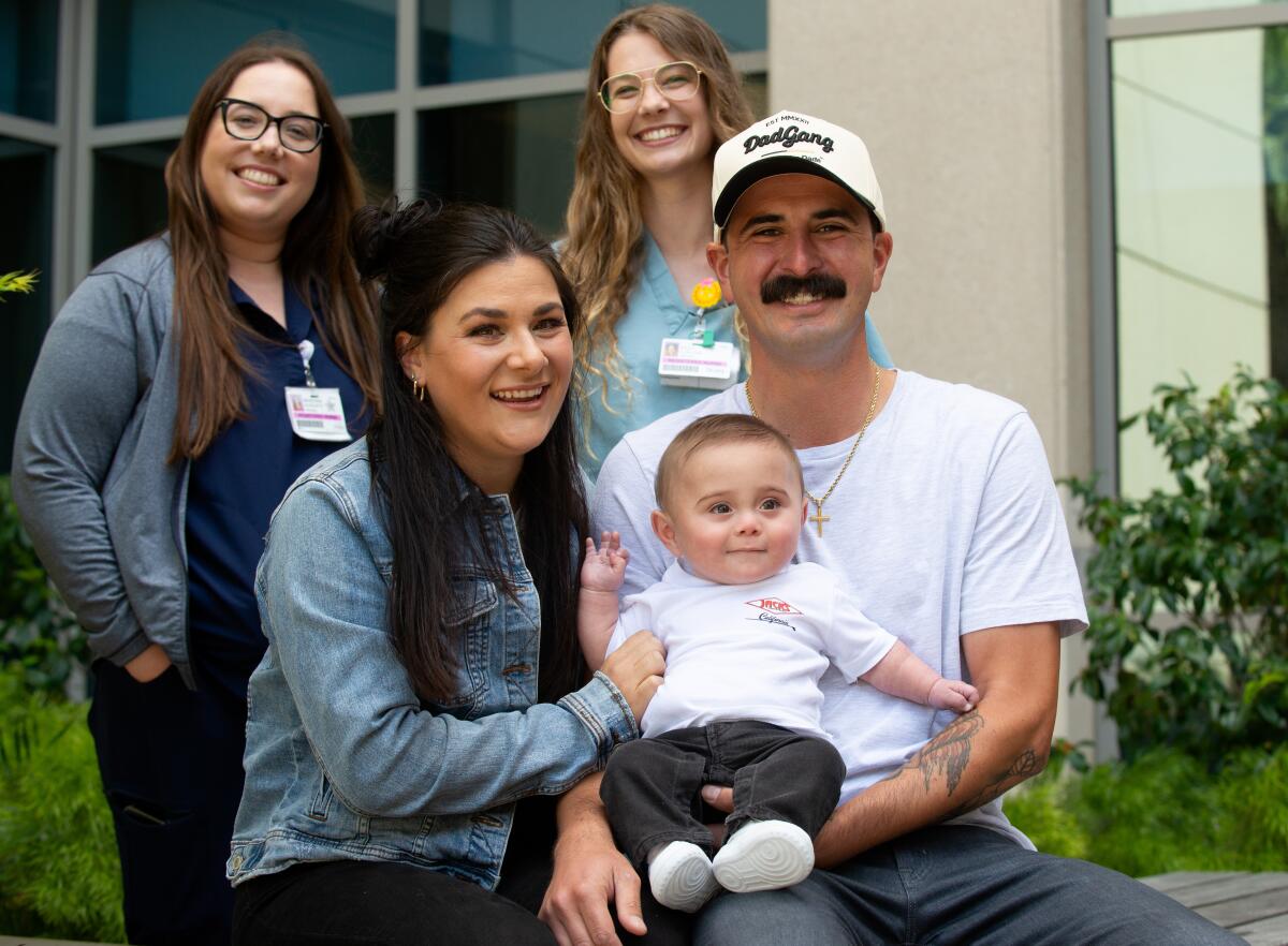 Megan, Jay Nova and Mikey Sanchez pose on Wednesday with NICU nurses Makenna Augusta and Kylie Collins. 