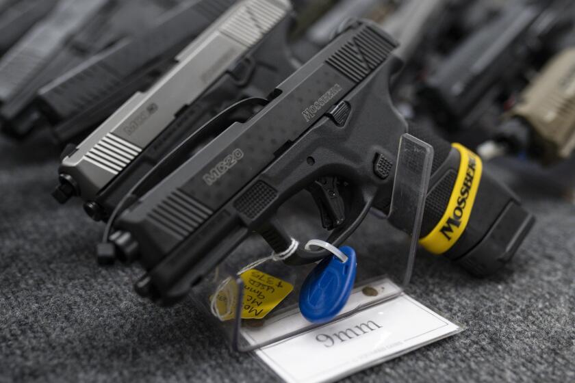 FILE - Pistols sit on display during the first day of the Silver Spur Gun and Blade Show, Jan. 22, 2022, in Odessa, Texas. On Monday, May 20, 2024, a federal judge blocked the Biden administration from enforcing a new rule in Texas that would require firearms dealers to run background checks on buyers at gun shows or other places outside brick-and-mortar stores. (Eli Hartman/Odessa American via AP, File)
