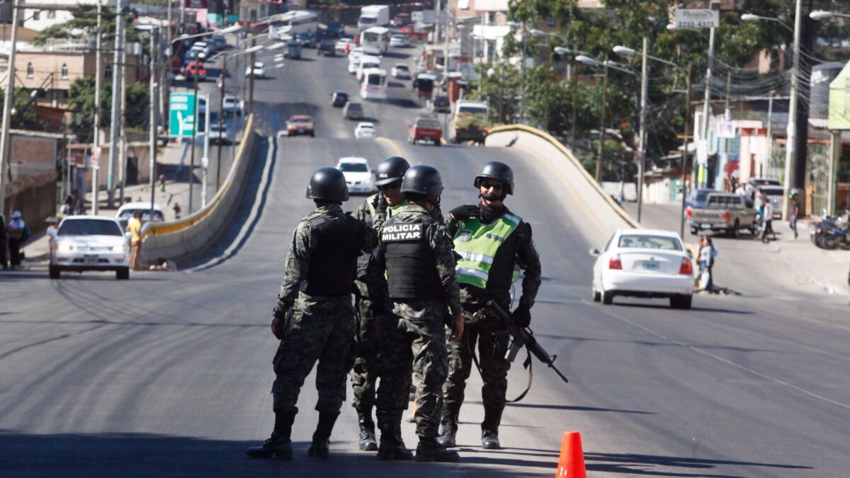 Soldiers monitor a checkpoint in Tegucigalpa, Honduras, which announced a curfew and suspended some constitutional rights.