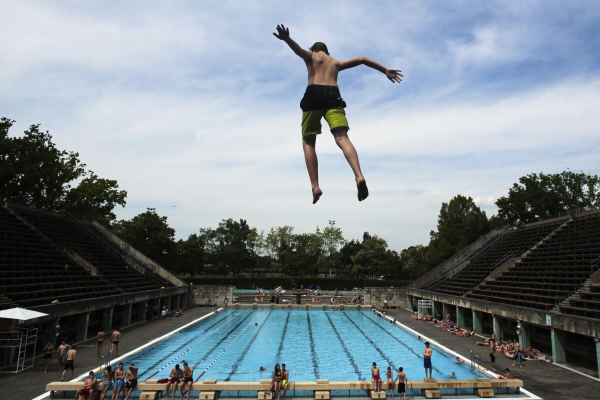 A boy jumps into a swimming pool