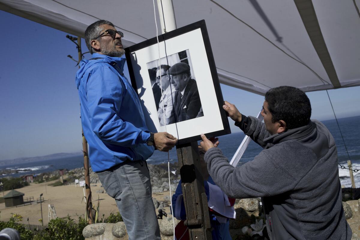 Trabajadores colocan un retrato del difunto poeta chileno ganador del Premio Nobel de Literatura Pablo Neruda