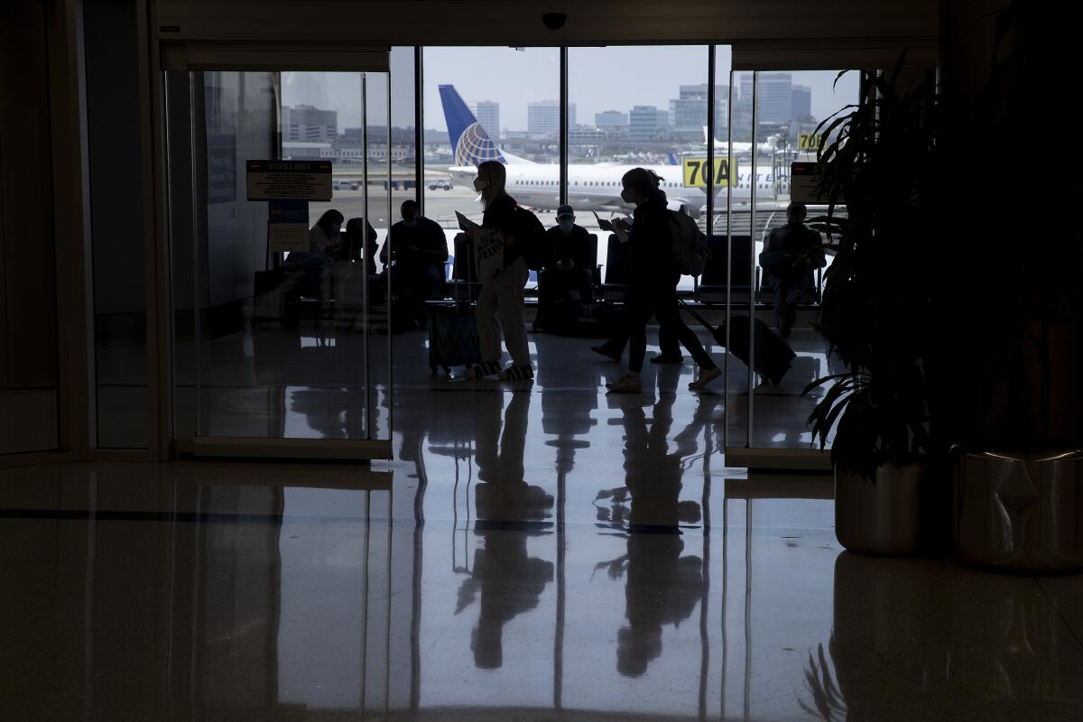 Travelers wait for flights in an airport terminal. 