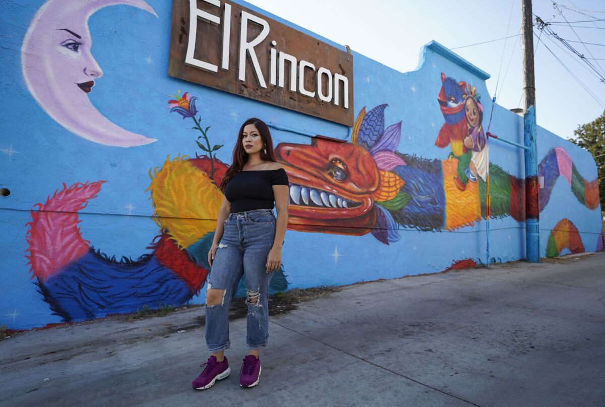 Artist Michelle Guerrero in front of her mural, "Quetzalcoatl Falls in Love with the Moon."