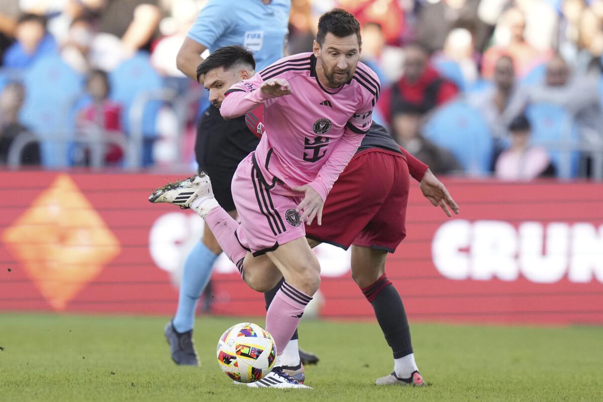 El argentino Lionel Messi, del Inter Miami, elude a Raoul Petretta, de Toronto, 