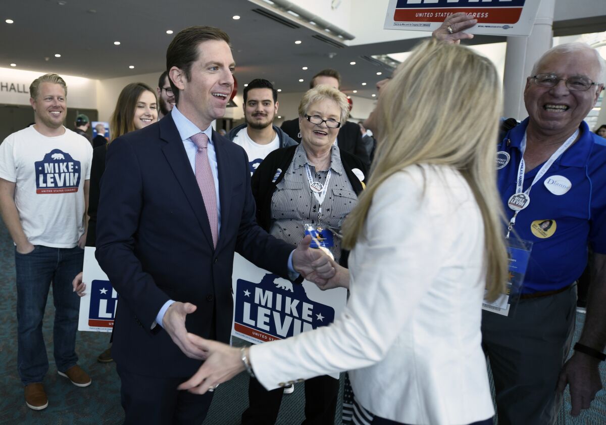 Democratic congressional candidate Mike Levin, left, talks with his wife Chrissy Levin in front of supporters at the 2018 California Democrats State Convention Saturday, Feb. 24, 2018, in San Diego. (AP Photo/Denis Poroy)