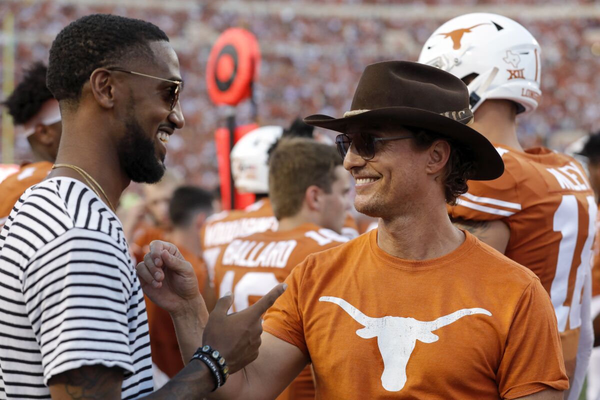 Former Texas Longhorns wide receiver Dorian Leonard talks with actor Matthew McConaughey 