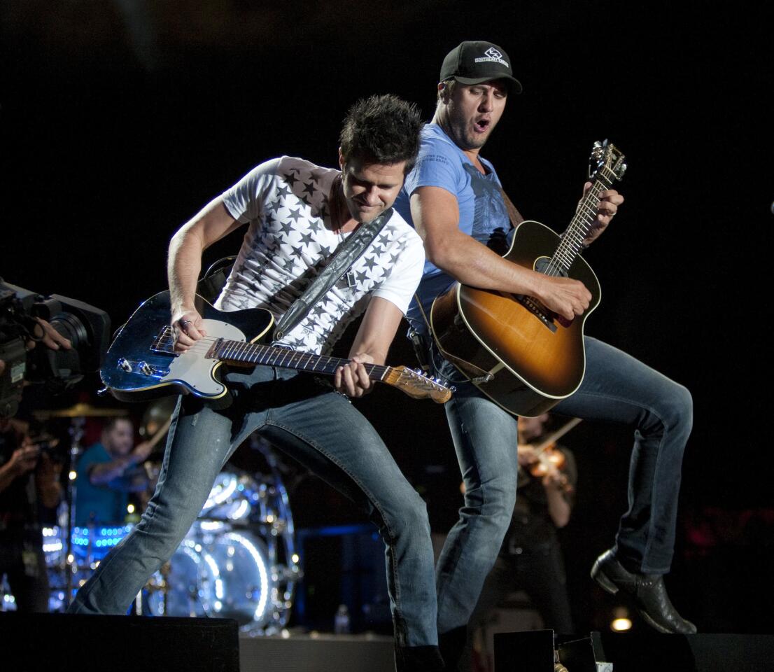 Luke Bryan and guitarist Michael Carter, left, perform their headlining show on the final day of the Stagecoach Country Music Festival at the Empire Polo Club in Indio.