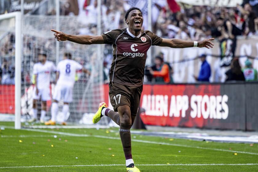 St. Pauli's Oladapo Afolayan celebrates scoring his side's second goal, during a second division Bundesliga soccer match between St. Pauli and VfL Osnabrück, at the Millerntor Stadium, in Hamburg, Germany, Sunday, May 12, 2024. (Axel Heimken/dpa via AP)