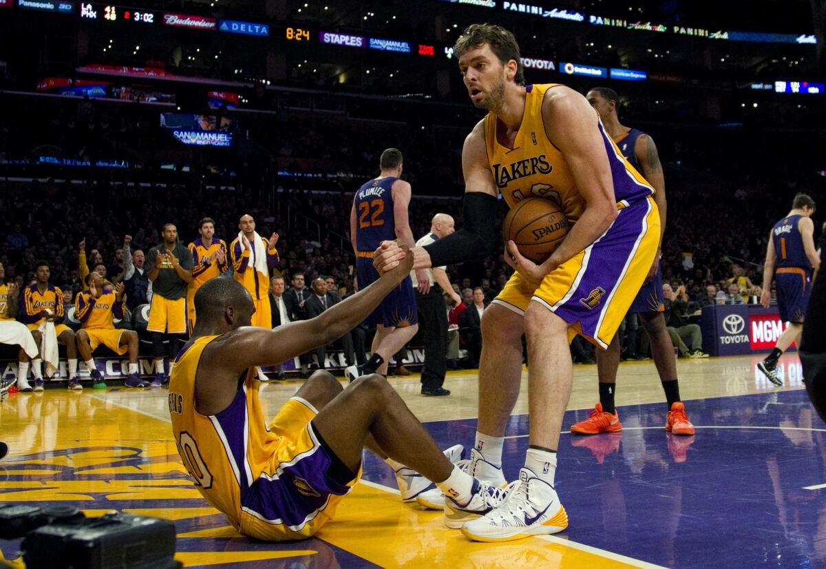 Lakers center Pau Gasol helps teammate Kobe Bryant to his feet after Meeks was fouled in Tuesday's game against the Phoenix Suns at Staples Center.