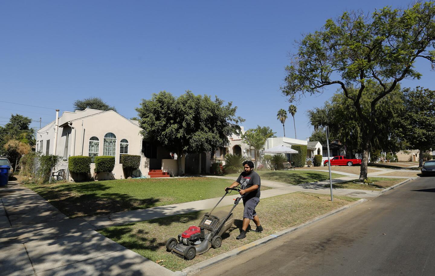 Gardener Leo Munguia mows the front lawn of a home on Sheffield Avenue in El Sereno that is owned by Caltrans. It is one of many properties purchased by the agency in the 1950s and '60s in anticipation of the 710 Freeway extension, which was never finished.