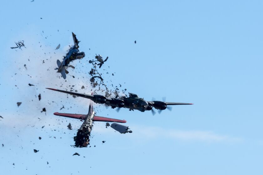 In this photo provided by Larry Petterborg, a Boeing B-17 Flying Fortress and a Bell P-63 Kingcobra collide in the midair during an airshow at Dallas Executive Airport in Dallas, Saturday, Nov. 12, 2022. (Larry Petterborg via AP)