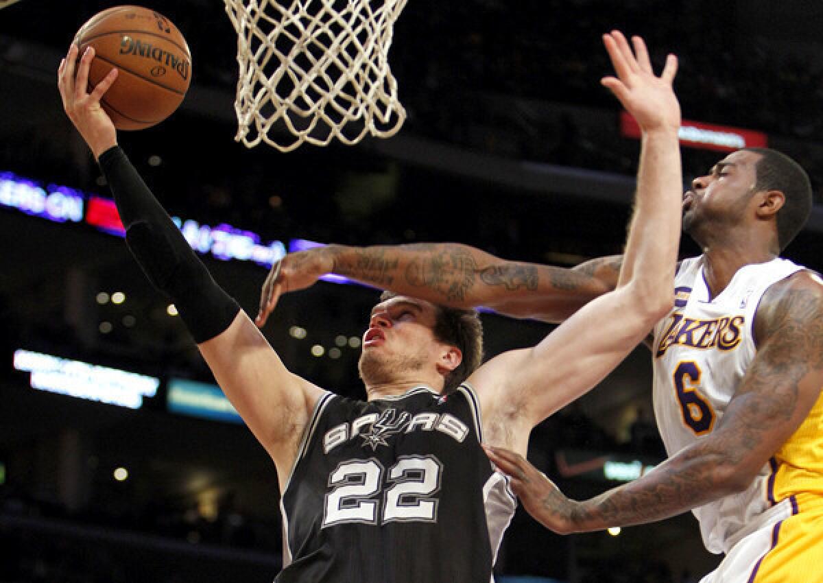 Lakers forward Earl Clark tries to block a shot by Spurs center Tiago Splitter.