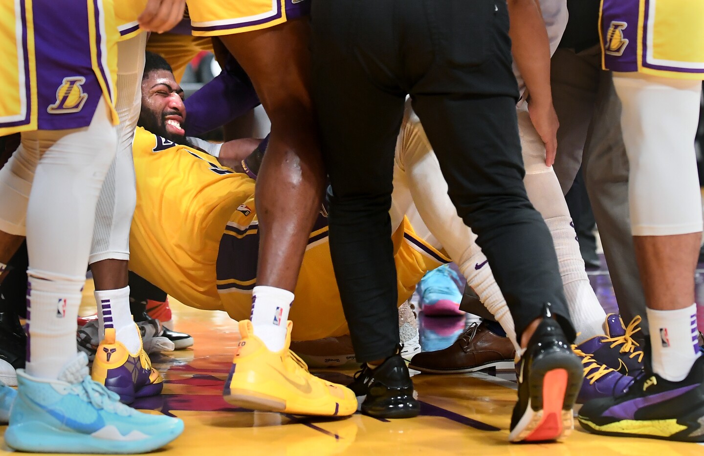 LOS ANGELES, CALIFORNIA JANUARY 7, 2020-Lakers Anthony Davis is helped off the court after falling on the floor against the Knicks in the 3rd quarter at the Staples Center Tuesday. (Wally Skalij/Los Angerles Times)