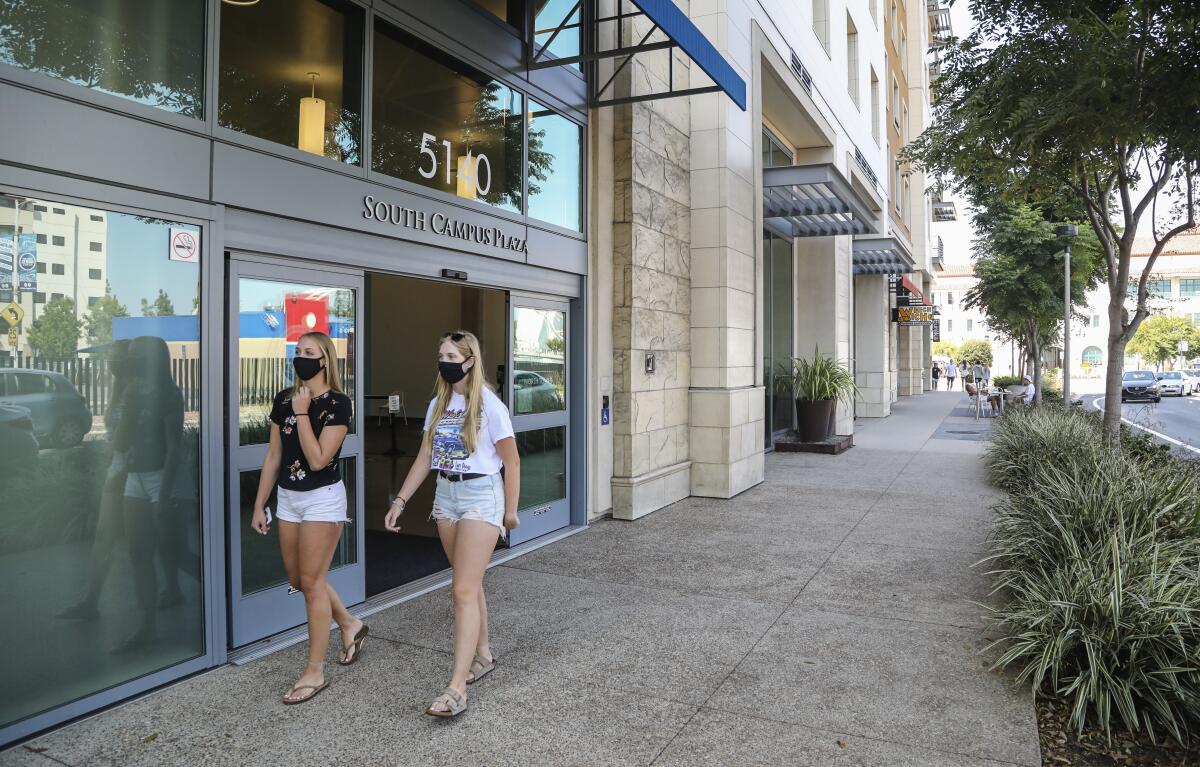 People walk past the South Campus Plaza apartments at SDSU on Wednesday.