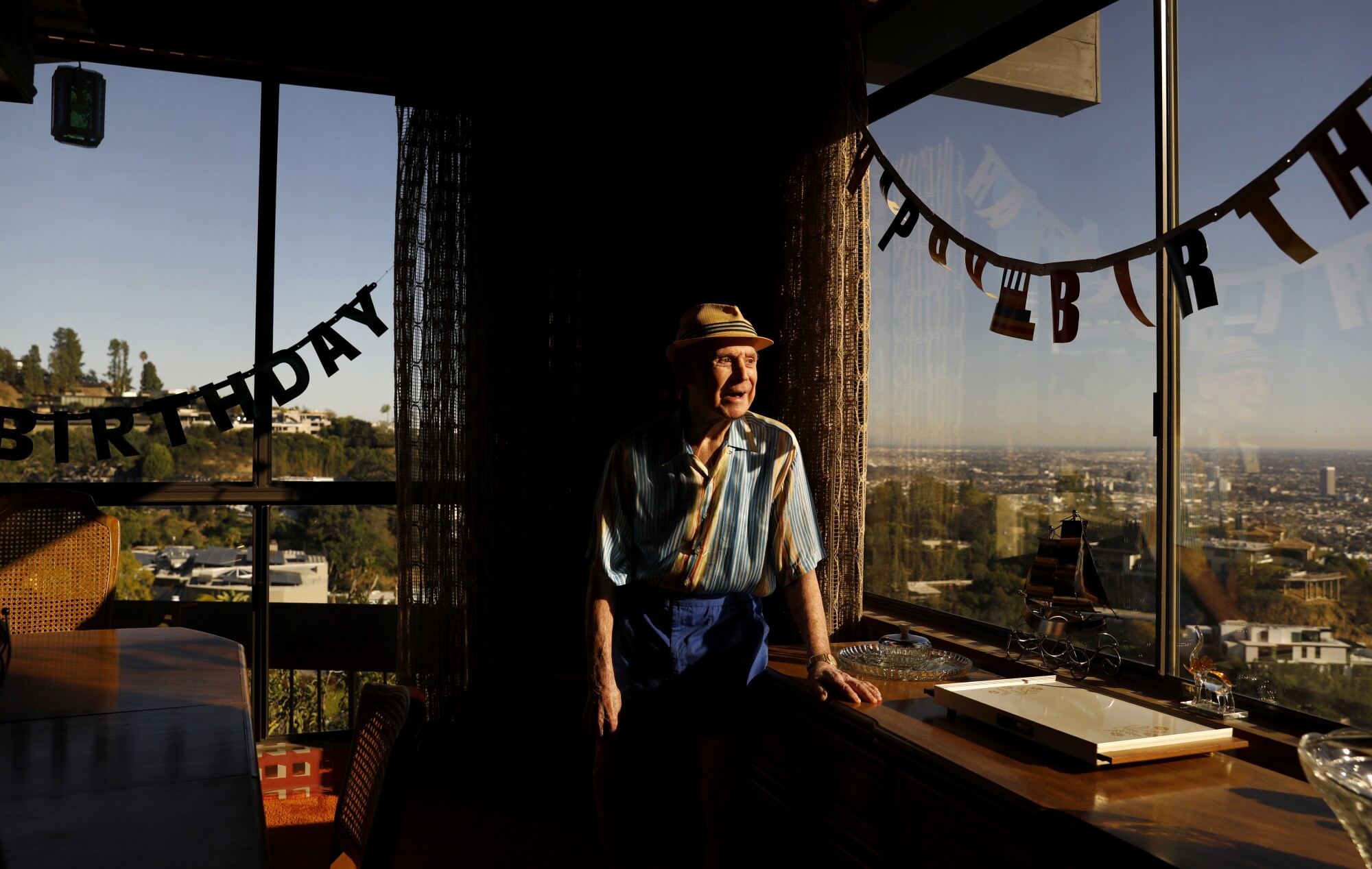 A man looks out his window.