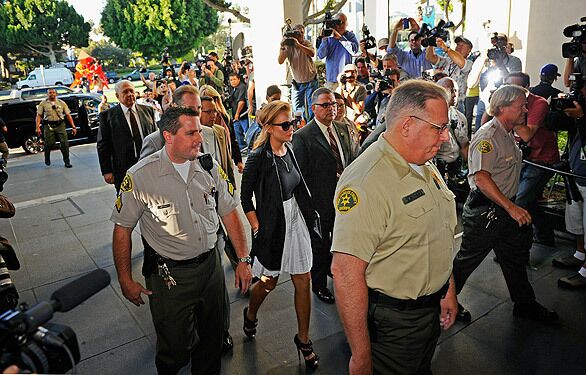 Lindsay Lohan is escorted by Los Angeles County sheriff's deputies into the Beverly Hills courthouse.