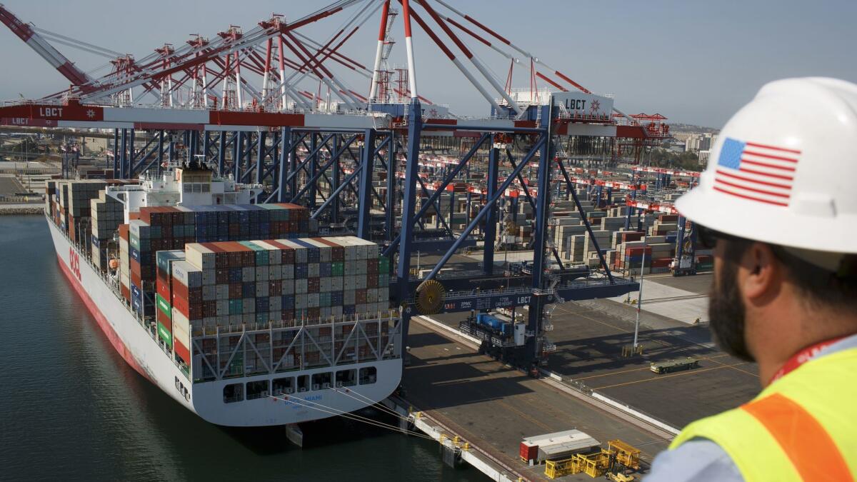 John Beghin, of the Long Beach Container Terminal at the Port of Long Beach, watches a container ship being uloaded from a nearby crane. The Los Angeles and Long Beach port complex will seek to slash air pollution and health risks to Southern Californians.