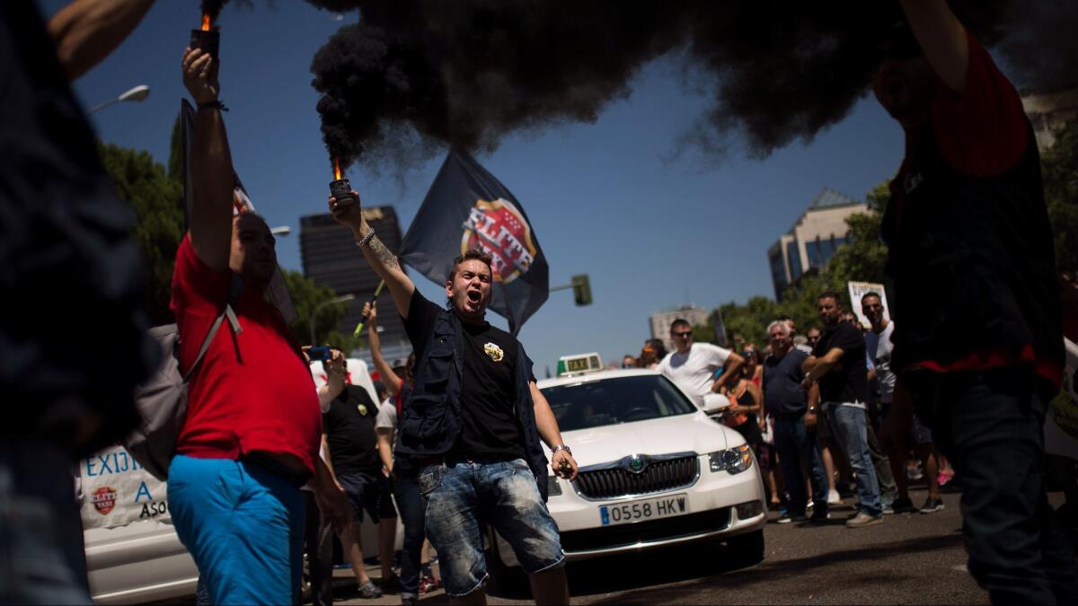 Taxi drivers and unions protest companies such as Uber and Cabify in Madrid in July. The European Union's top court ruled Wednesday that ride-hailing service Uber should be regulated like a taxi company.