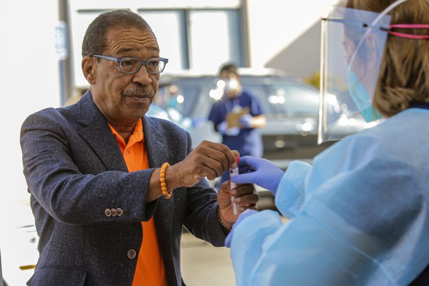 LOS ANGELES, CA - OCTOBER 03: Councilman Herb Wesson, left, gives himself a COVID-19 test at a free drive-thru test site he held in collaboration with Kheir Clinic at his district office on Saturday, Oct. 3, 2020 in Los Angeles, CA. (Irfan Khan / Los Angeles Times)