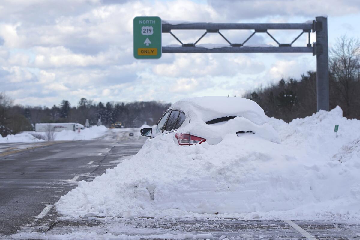 Un automóvil varado y cubierto de nieve en una carretera en Orchard Park, Nueva York