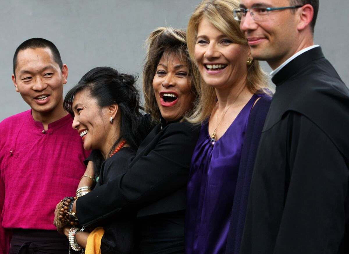 Tina Turner stands at center with Buddhist and Christian faith leaders on either side of her