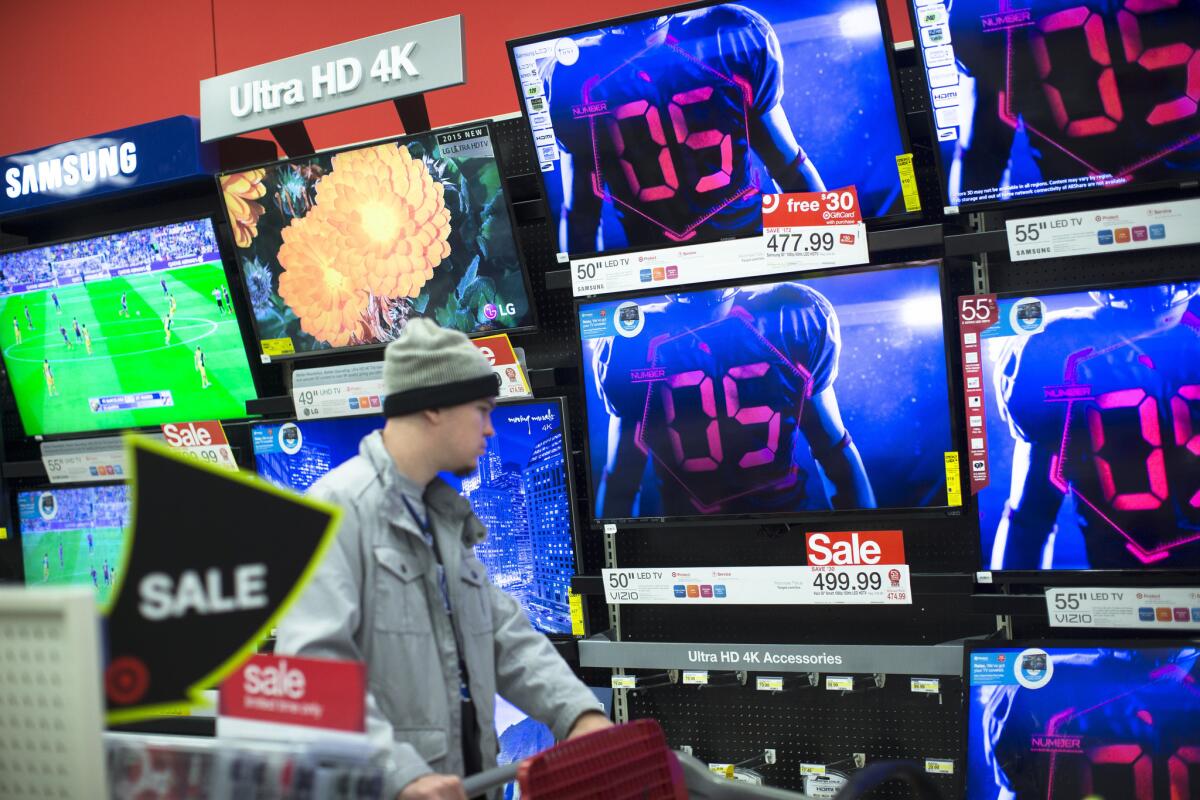 A shopper browses the electronics section against a backdrop of televisions at a Target store in Newport, Ky., on Nov. 27, 2015.