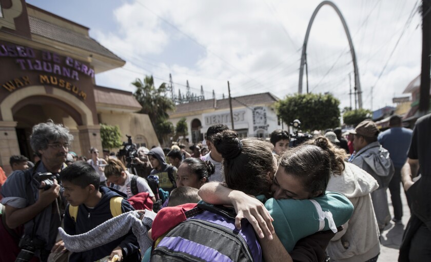 Varios migrantes hacen una fila en un cruce fronterizo en Tijuana, México, mientras esperan para solicitar asilo en Estados Unidos.