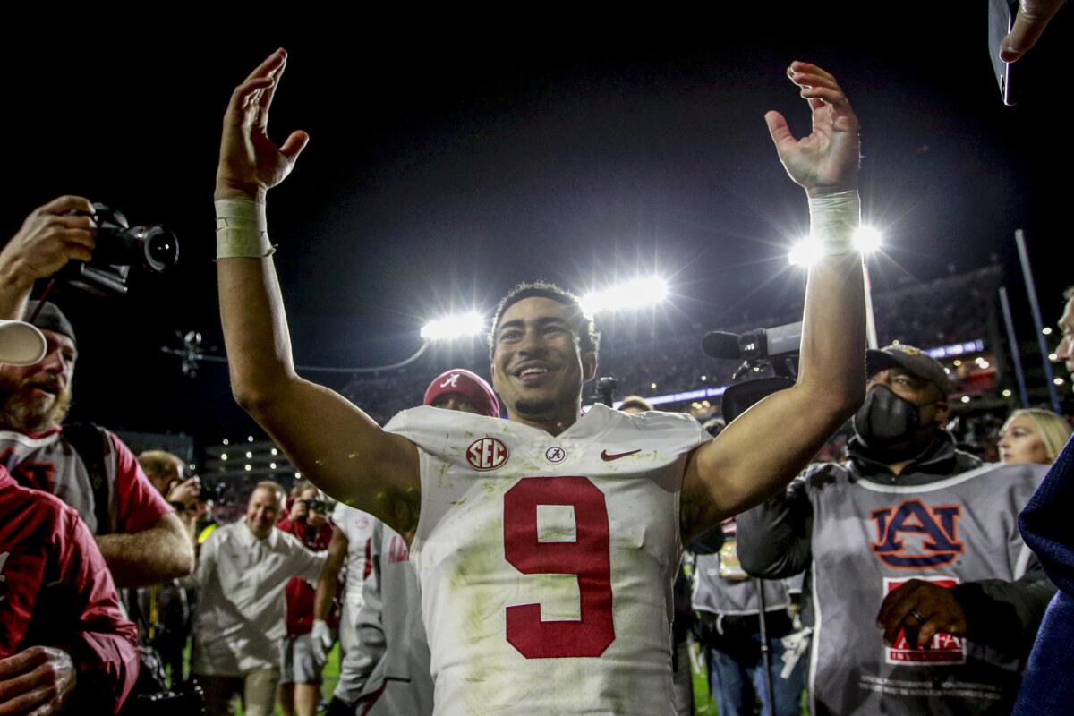 Alabama quarterback Bryce Young smiles and lifts his arms as he celebrates after a win 
