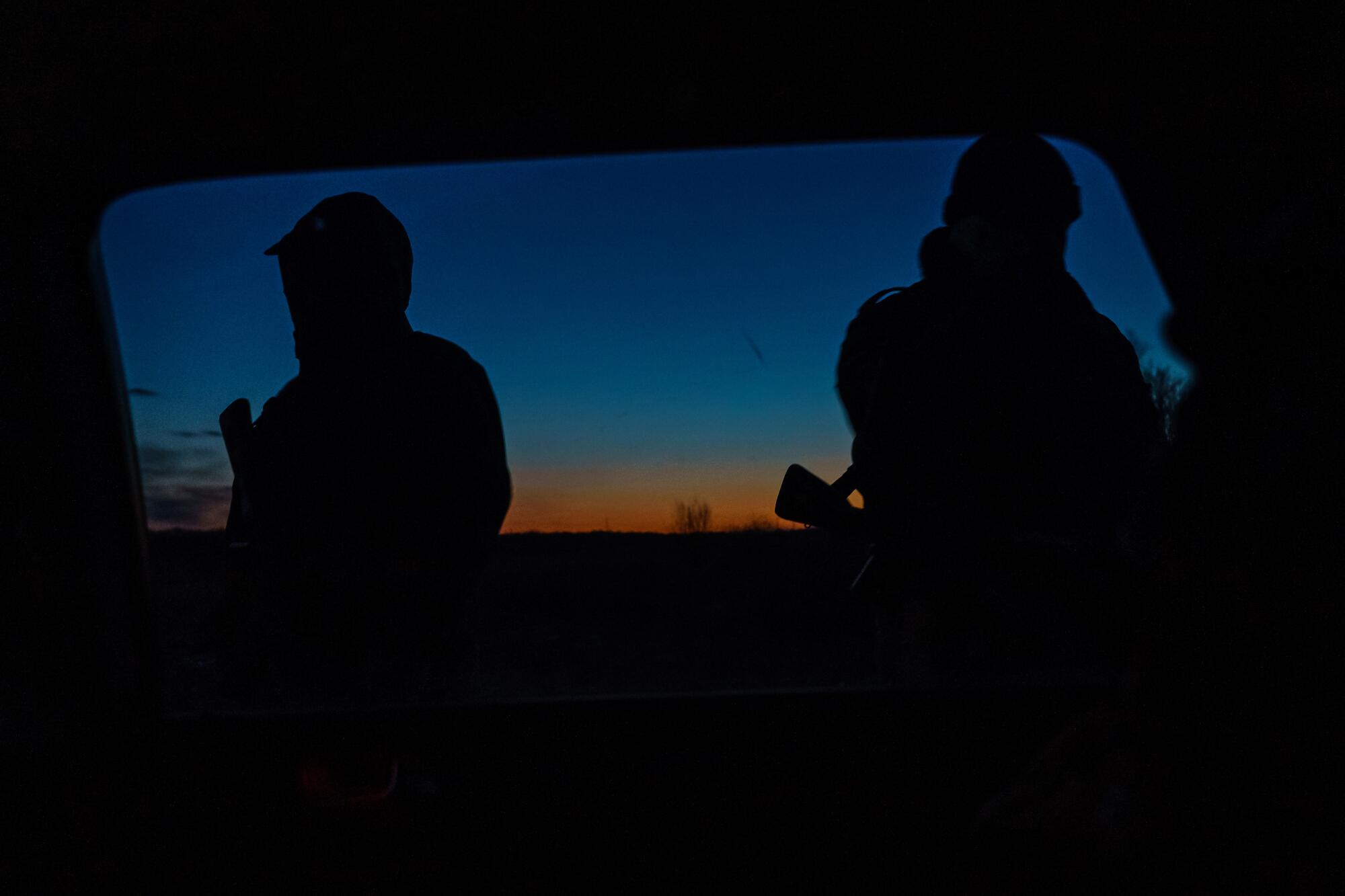 Volunteer fighters stand outside vehicle while identification is verified.