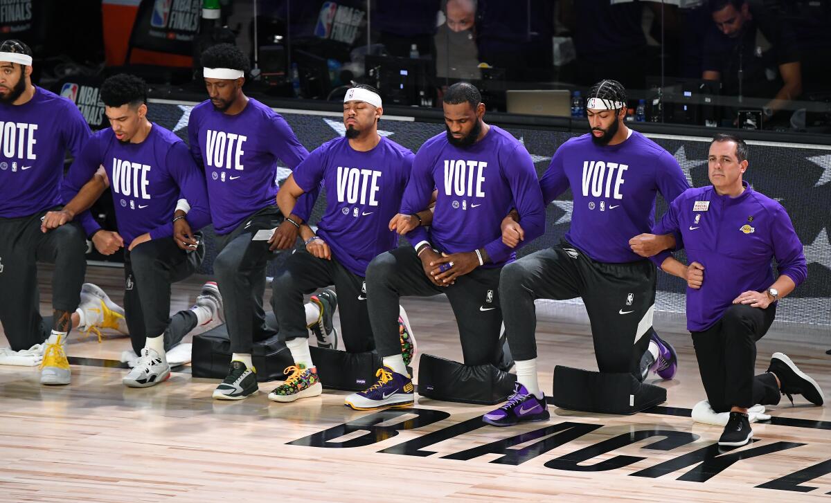 The Lakers take a knee during the national anthem before Game 1 of the NBA Finals.