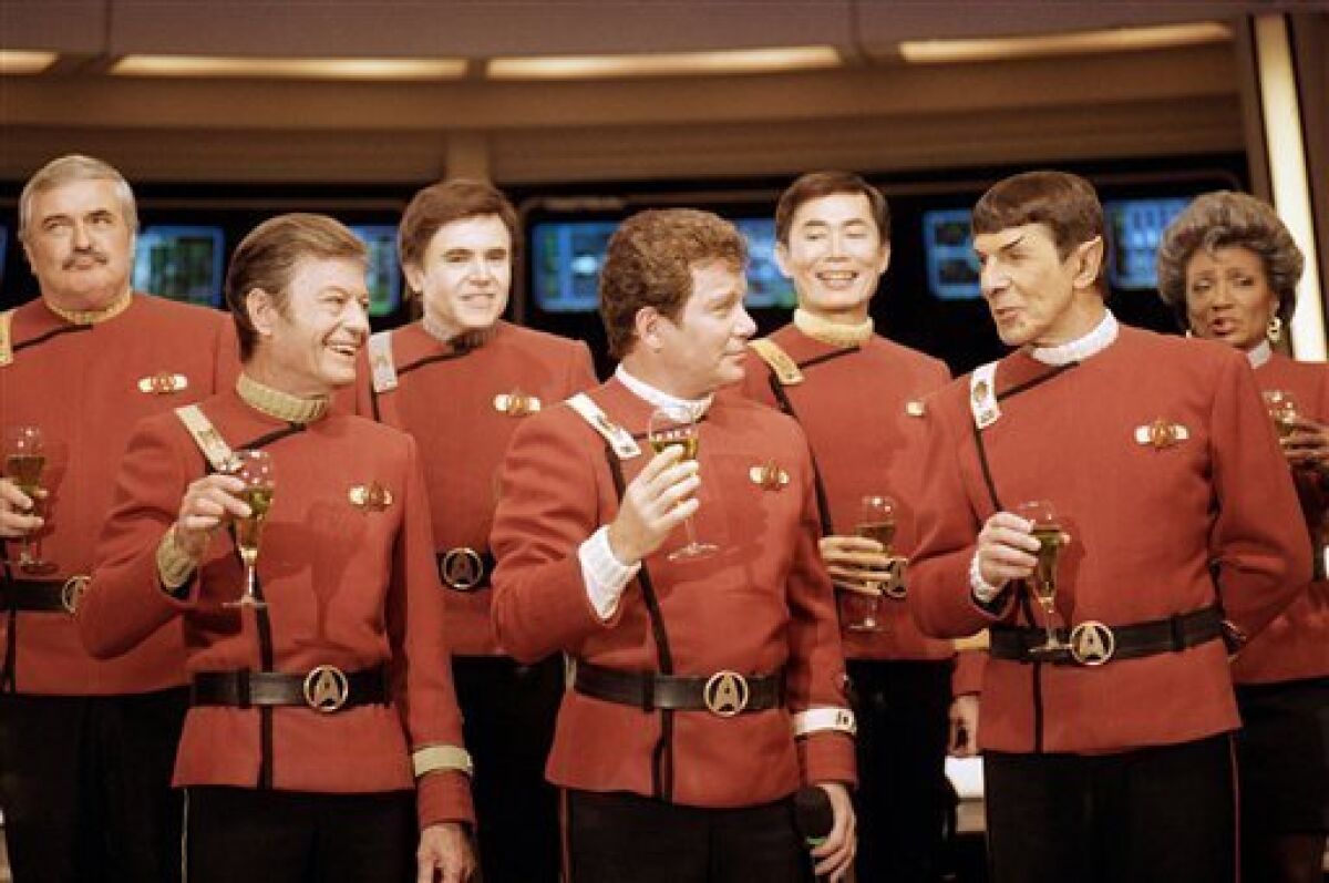 FILE- In this Dec. 28, 1988, file photo shows members of the "Star Trek" crew, from left, Nichelle Nichols, Leonard Nimoy, George Takei, William Shatner, Walter Koenig, DeForest Kelley and James Doohan, toast the newest "Star Trek" film during a news conference at Paramount Studios. (AP Photo/Bob Galbraith,File)