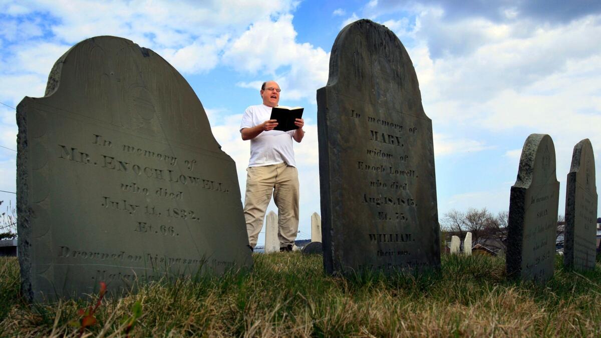 Walter Skold reads a Henry Wadsworth Longfellow poem while standing in front of the tombstones in Eastern Cemetery in Portland, Maine.