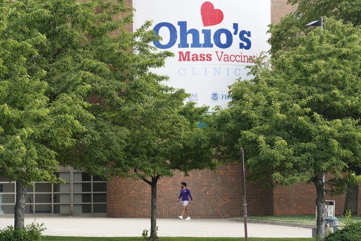 FILE - In this May 25, 2021, file photo, a man walks by the entrance for Ohio's COVID-19 mass vaccination clinic at Cleveland State University in Cleveland. Ohio plans to announce its third pair of Ohio Vax-a-Million winners Wednesday evening, June 9, 2021, even as the initial bump from the incentive program fades and the vaccination numbers continue to drop. (AP Photo/Tony Dejak, File)