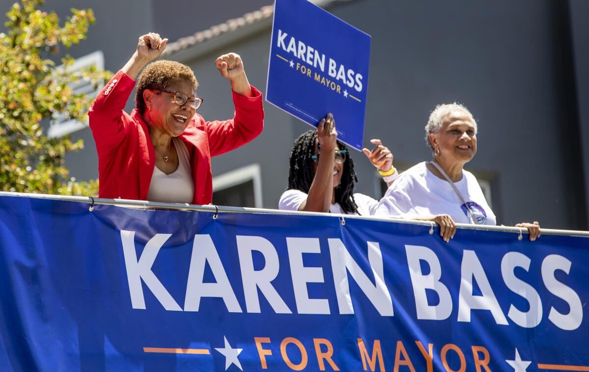 Mayoral candidate Rep. Karen Bass cheers at supporters from a double-decker bus while campaigning on Sunday.