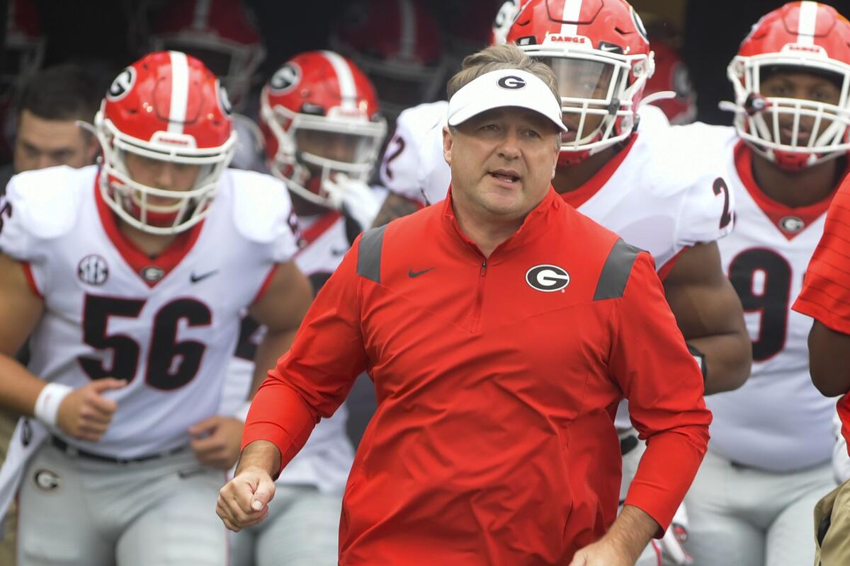 Georgia coach Kirby Smart runs ahead of his players before a game against Vanderbilt.