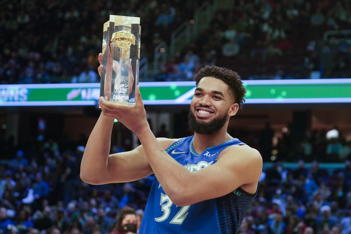 The Timberwolves' Karl-Anthony Towns holds the trophy after winning the three-point shooting competition Feb. 19, 2022.
