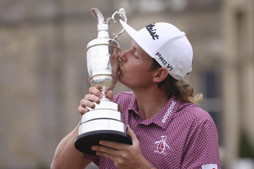 Cameron Smith, of Australia, kisses the claret jug trophy as he poses for photographers on the 18th green after winning the British Open golf Championship on the Old Course at St. Andrews, Scotland, Sunday July 17, 2022. (AP Photo/Peter Morrison)